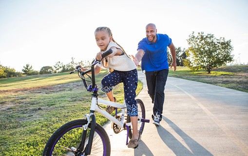 Father and daughter riding bikes