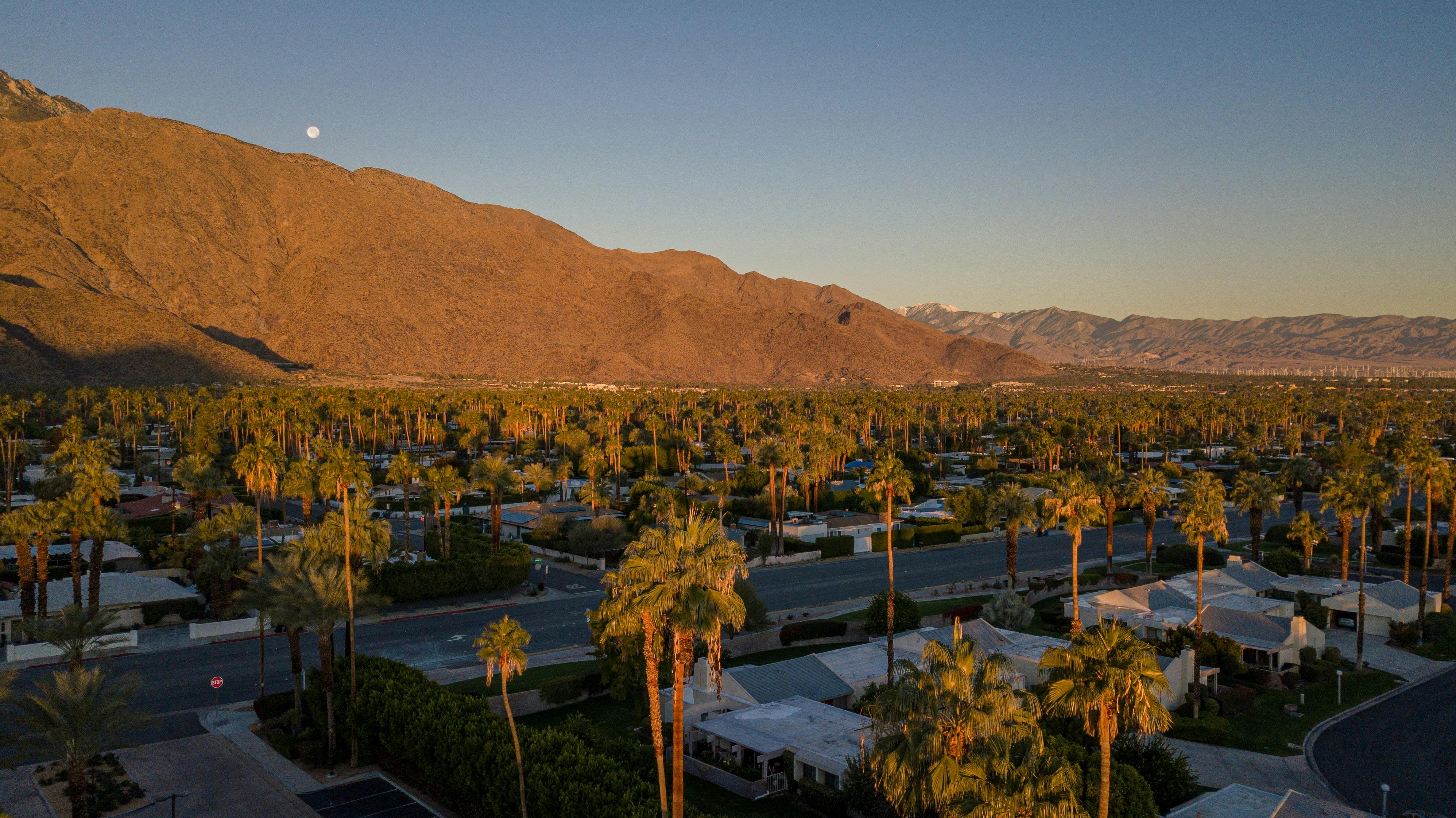 Palm Springs desert town at golden hour with mountains beyond