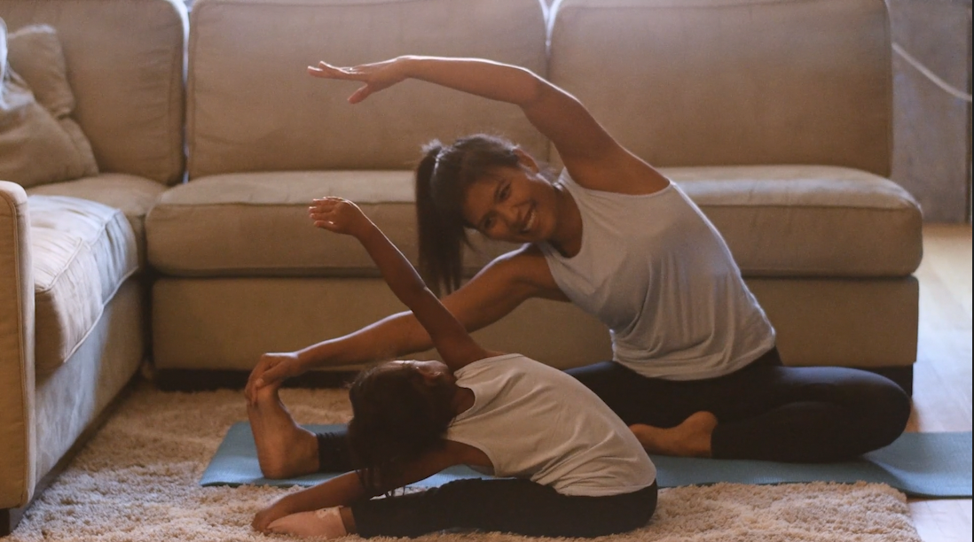 Mother and daughter doing yoga at home